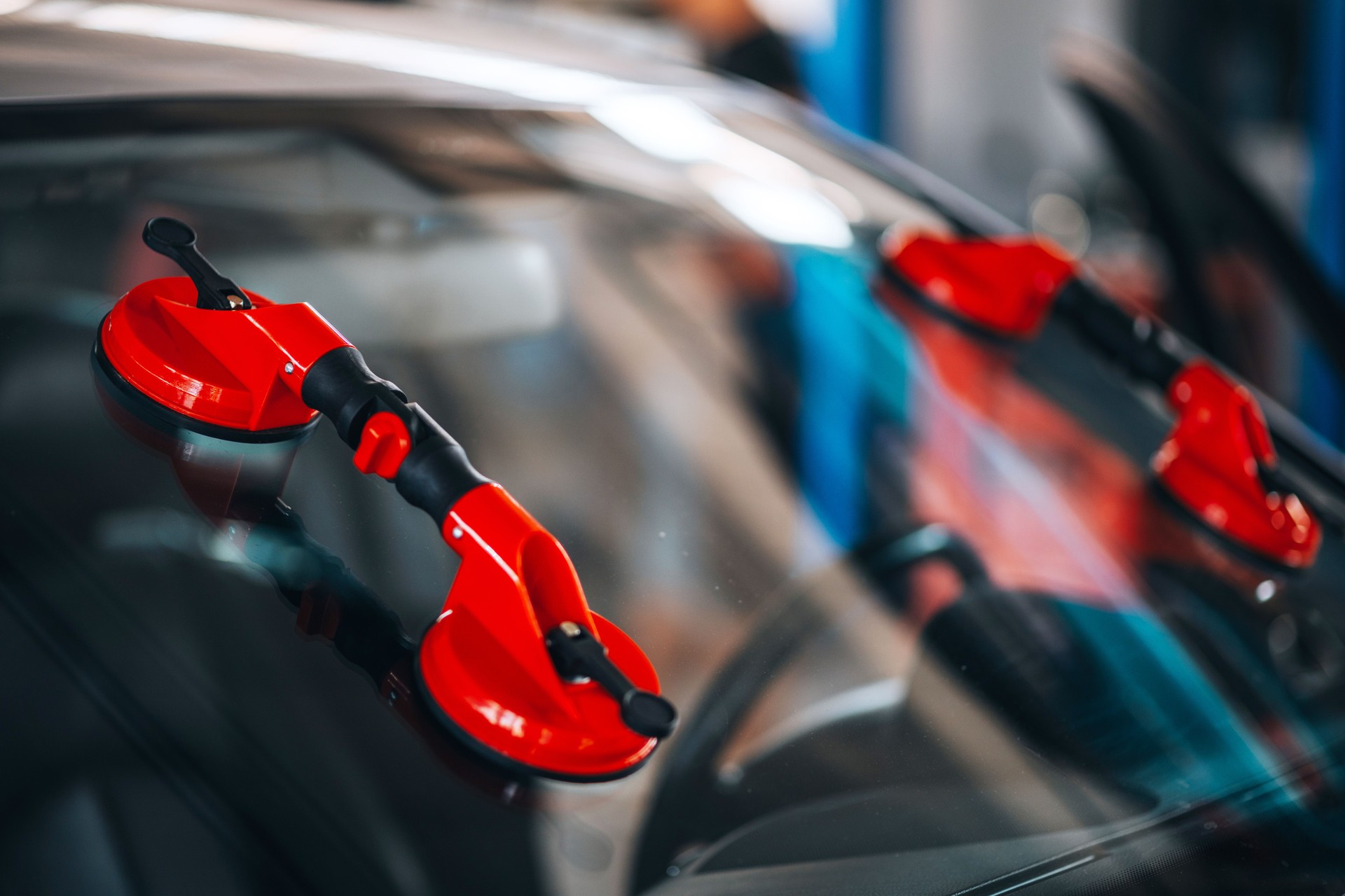 Red suction cup lifter on a car  windshield